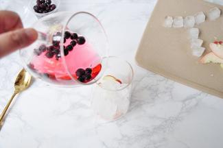 再将泡好的黑醋栗缓缓倒入杯中。