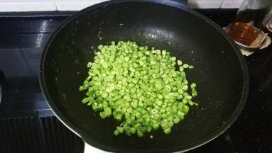 锅里继续放入30g牛油，倒入四季豆圈