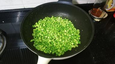翻炒均匀放入盐糖调味再炒几下后将四季豆平铺锅里1分钟