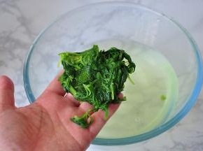 选取芹菜的嫩叶，清洗干净后入沸水略粘，捞出后过凉，再挤净水份备用。