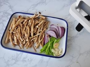 首先打开烹饪机的手机APP程序，搜到自己需要制作的菜。如果在菜单中没有我们想要做的，我们可以通过寻找类同的菜谱来操作。我选的是干锅茶树菇。然后准备好食材。将茶树菇去掉老根，然后仔细清洗，茶树菇在清洗的过程中，伞盖都碎了，所以只剩下菌杆了，将蒜姜切片，洋葱青椒切丝备用。