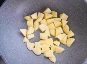 锅中倒少许油烧热，土豆块控干水分，倒入锅中，中小火煎至表面微黄。