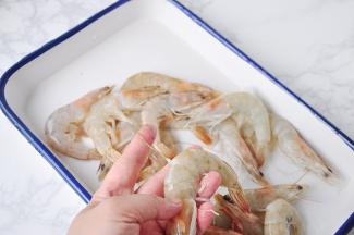 首先把虾处理一下。虾一定要记得去除虾线，虾线中会有或多或少的脏东西，吃到嘴里会碜牙，非常影响口感，我们只需用牙签在虾头部下的第二个关节处挑一下，就能挑出。