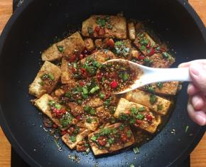 将调料均匀的倒至豆腐表面；