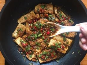 将调料均匀的倒至豆腐表面；
