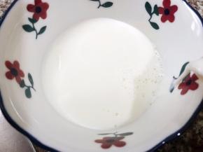 再把牛奶从边缘倒回碗里