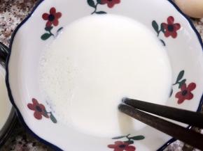 等稍微晾凉，表面有一层奶皮，用筷子从边缘戳开奶皮把牛奶倒出来