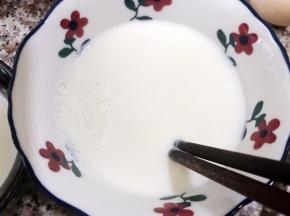 等稍微晾凉，表面有一层奶皮，用筷子从边缘戳开奶皮把牛奶倒出来