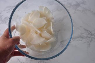 将萝卜片放在容器中，加入盐抓匀，大约腌制半小时左右。