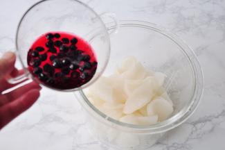 将糖腌好的萝卜再次挤净水份。黑醋栗取二十粒左右提前用温水泡出种颜色放凉。