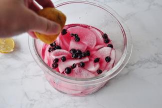 将泡好放凉的黑醋栗与水一起倒入萝卜中。然后再挤入柠檬汁。