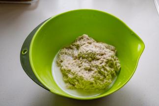 倒入面筋粉，边倒入边用筷子搅拌，避免面粉结疙瘩，出现面疙瘩就用手搅散捏开。面粉吸足水分后变成粗拉拉的面团，盆里有多余的水，直接倒掉就好。