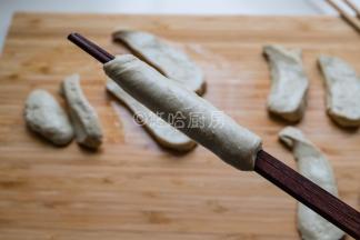 用一双筷子先夹住面筋的一头，一手拉伸拉长面团，一手转动筷子，让面团斜着缠绕在筷子上，最后的面团要抻开抻薄包裹住筷子上的面团，最后就是图中的样子。面团最后不抻薄也可以，直接缠绕就行。