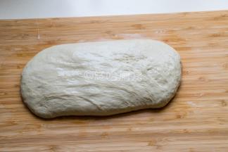 取出静置后的面团至案板上，这时的面团已经变得氺溜光滑，盆里会有水，倒掉即可。