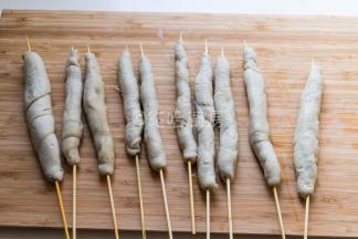 煮好的面筋用竹签串起来。