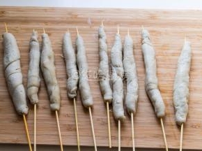 煮好的面筋用竹签串起来。