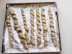 用刀顺着面筋切一圈，然后用手拉伸开面筋，放入铺锡纸的烤盘中。