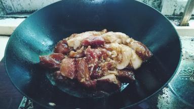 锅里开大火放入腌好的肉，翻炒一下
