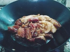 锅里开大火放入腌好的肉，翻炒一下
