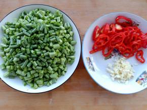 豆角洗净切小段，红椒切丝，大蒜切末