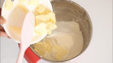 加入软化切小块的黄油，戴手套将黄油和面粉揉搓均匀。