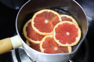 1. 血橙用盐搓洗干净，切成薄片，放入奶锅内，加入细砂糖和冷水，小火煮慢煮至西柚片白色部分变透明。