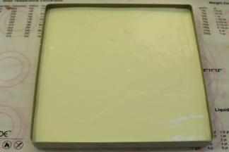 拌好的蛋糕糊倒入刚才放好西柚片的方盘内，刮平。