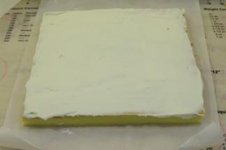 均匀的抹好淡奶油，底部要抹得少一点，利用擀面杖卷好蛋糕卷。