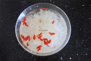 将清洗干净的鲜银耳剪碎和枸杞一起浸泡15分钟左右。