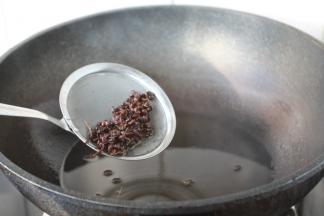 当花椒颜色微微变深，随后捞出花椒，改大火，加热一下花椒油，使油温达到5～6成热。
