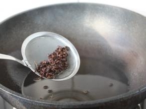 当花椒颜色微微变深，随后捞出花椒，改大火，加热一下花椒油，使油温达到5～6成热。