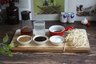 准备食材：前排从左起依次是芝麻酱、酱油、盐、面条，后排从左起依次是花生油、矿泉水、花椒。
