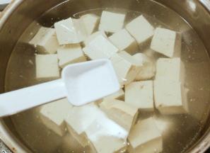 先用开水煮豆腐 水中加入2克盐  去除豆腥味  同时增加豆腐的韧性