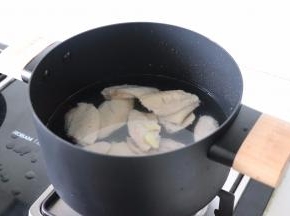 把姜片和鸡翅一起放入冷水锅中，加盖烧开。
