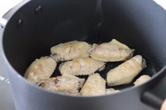 干净的锅中开火，倒油，油热后放入鸡翅煎一下。两面都煎到稍变色。