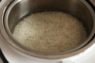 将米倒入蒸饭煲内，加入刻度1位置的水泡半小时左右，蒸20分钟