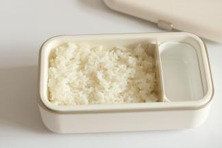 将日本酱油到少许在碗或者饭盒底部，寿司饭盛入均匀铺到表面