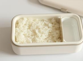 将日本酱油到少许在碗或者饭盒底部，寿司饭盛入均匀铺到表面
