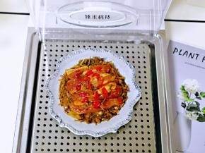 将“臻米折叠蒸汽锅” 连接电源，放上底层的蒸格，盘子摆在上面。