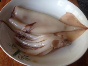 将鱿鱼外层红膜撕去，然后冲洗干净