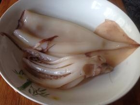 将鱿鱼外层红膜撕去，然后冲洗干净