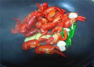 把虾下入锅中，爆炒上色