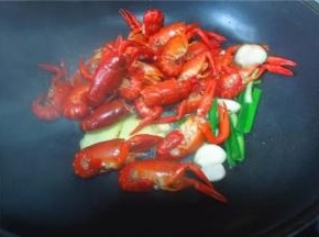 把虾下入锅中，爆炒上色