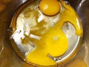 盆里打入2个鸡蛋和清水10克