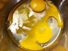 盆里打入2个鸡蛋和清水10克