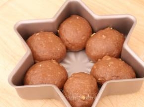 .松弛好的面团压扁，再次滚圆后放入模具中。