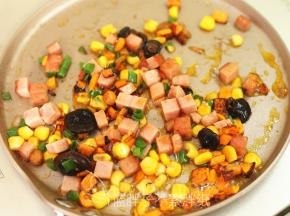 倒入玉米粒、午餐肉和香菇酱、香葱，翻炒至熟透。