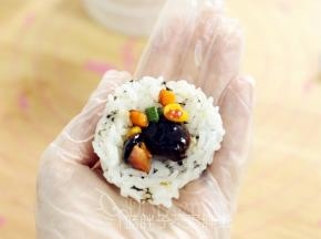 取一个饭团，包入炒好的胡萝卜等。