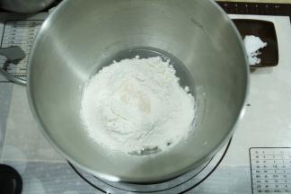 打面桶中，先液体，盐、糖分两个角落放入，再放粉类。酵母在粉类上挖洞放入。