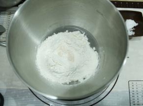 打面桶中，先液体，盐、糖分两个角落放入，再放粉类。酵母在粉类上挖洞放入。